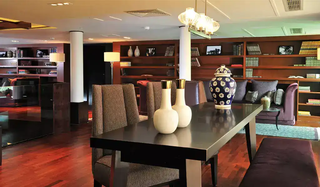 Elegant lounge aboard the M/S City & Sea Adonis with modern furnishings and library shelving.