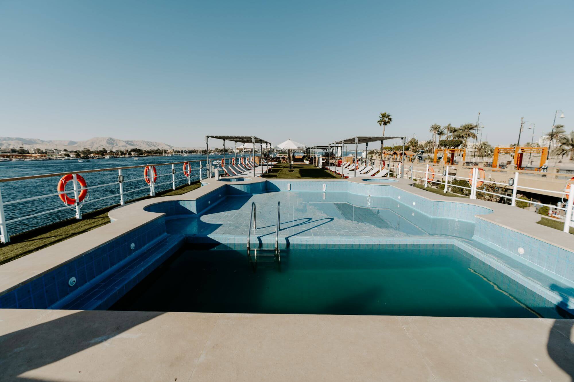 Swimming pool aboard the M/S City & Sea Adonis with Nile River views and sun loungers.