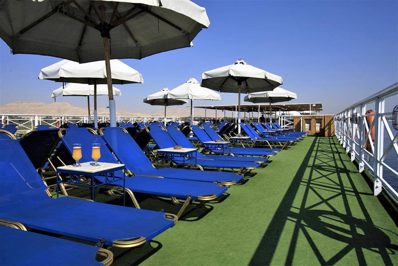Sun deck with blue loungers, white umbrellas and desert views aboard the M/S City & Sea Adonis