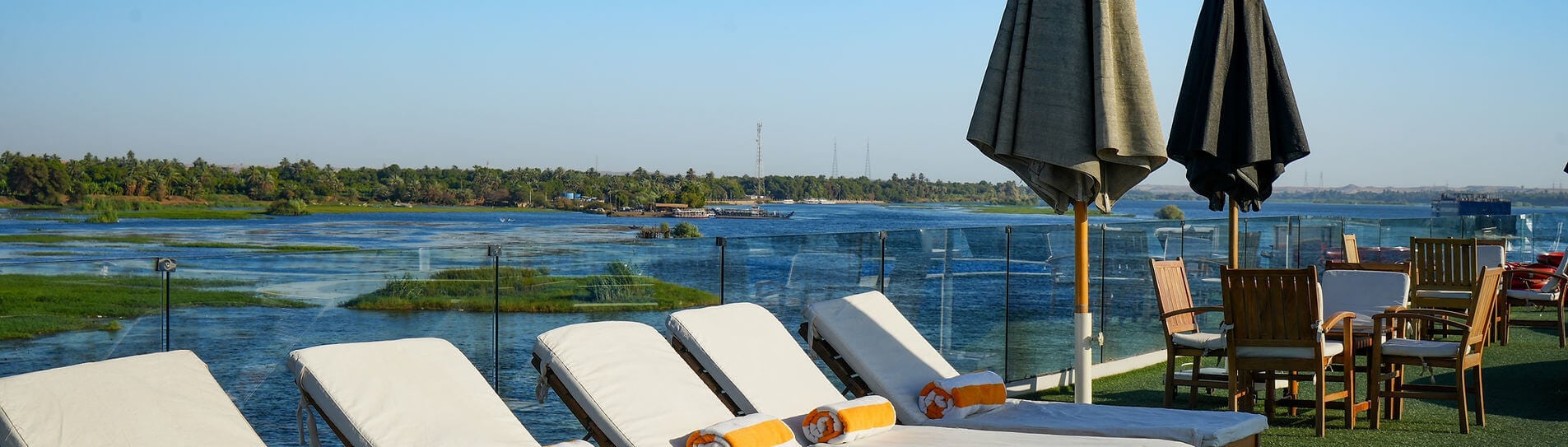 Lounge chairs and umbrellas on sun deck overlooking the Nile River aboard M/S City & Sea Adonis.