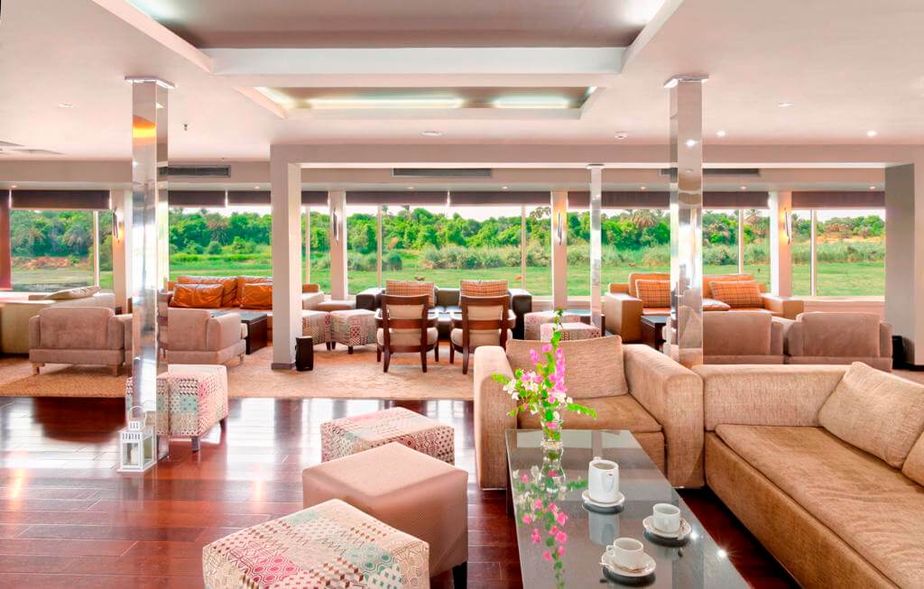 Spacious lounge aboard the M/S City & Sea Adonis with panoramic Nile views and elegant furnishings.