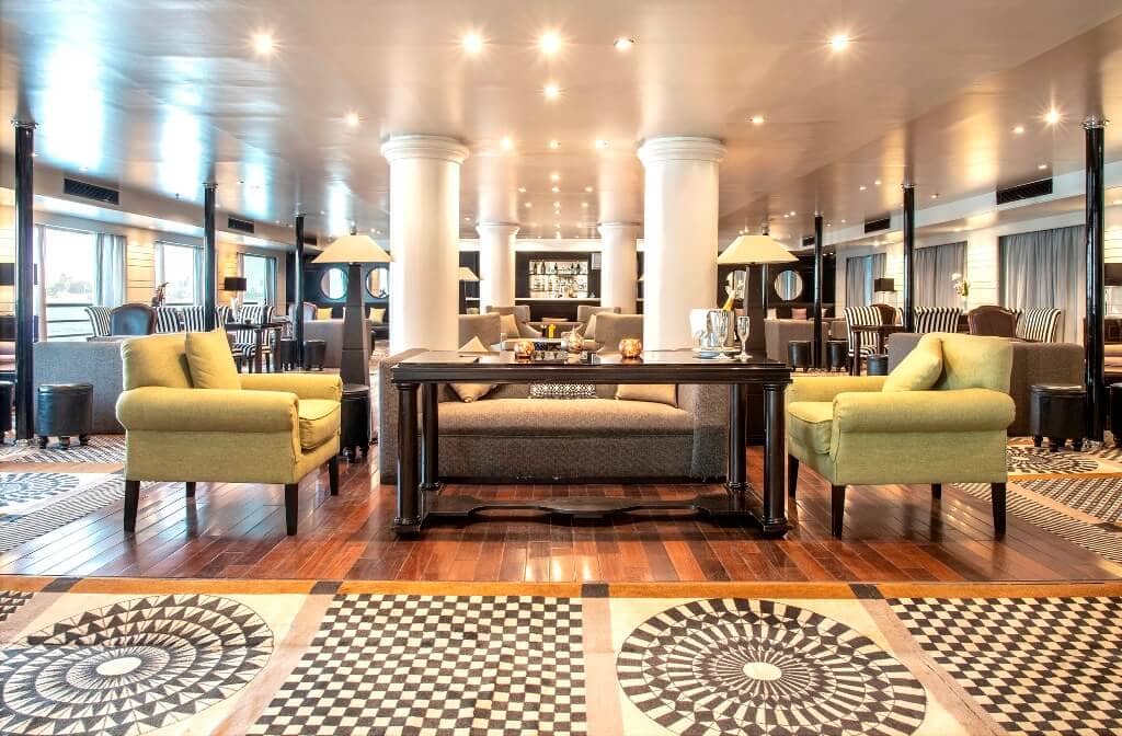 Elegant lounge aboard the M/S City & Sea Adonis with yellow armchairs and geometric floor patterns.