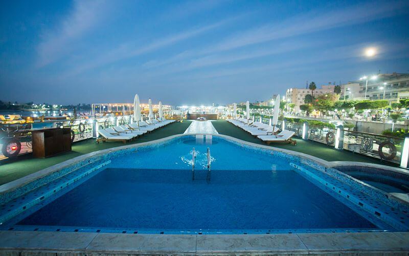 Swimming pool aboard the M/S City & Sea Adonis at dusk with Nile River view