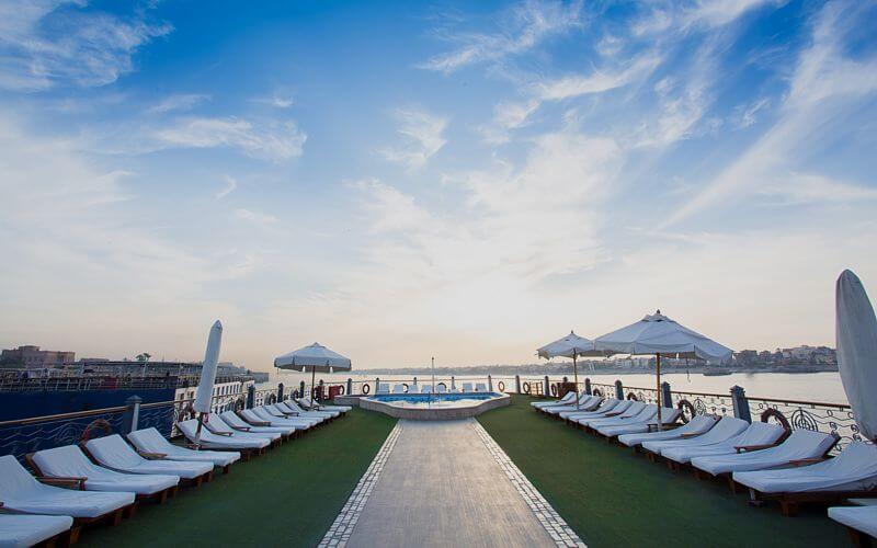 Sun deck aboard the M/S City & Sea Adonis with loungers and pool overlooking the Nile River.